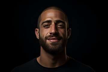 Portrait of a young man with a beard on a black background