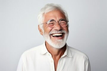 Portrait of a smiling senior man with white beard and glasses.