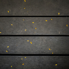 Dark wooden decking background texture with bright yellow leaves - 745466122