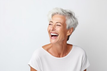 Portrait of a happy senior woman laughing against a white background. - obrazy, fototapety, plakaty