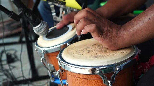 A percussion instrument called Ketipung is being played by a musician to accompany an Indonesian dangdut song