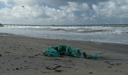 Broken blue fish net on sand Ocean Beach Pier and Dog Beach