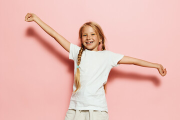 Young girl posing happily on pink background