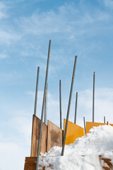 雪に刺さって青空に伸びる鉄パイプ
