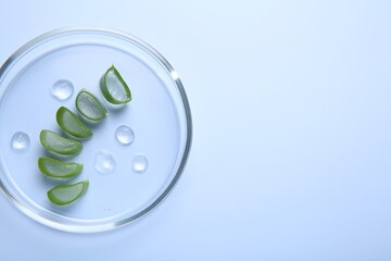 Cut aloe vera and drops of cosmetic gel on light blue background, top view. Space for text