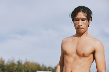 Smiling Asian Man Enjoying Summer Vacation: Swim, Fun, and Relaxation in Tropical Blue Water