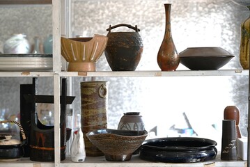 A view of a Japanese antique store. This store is filled with a variety of products such as pottery, antiques, and miscellaneous goods.