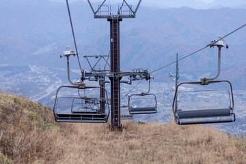 Hakuba, Japan - 4 November 2023 : Quad lift chairs operating during autumn going up and down a...