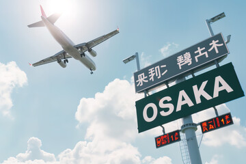 Plane landing in Osaka, Japan with "OSAKA" road sign in frame	