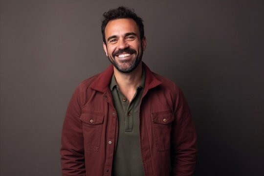 Portrait of a happy casual man smiling at the camera on a dark background