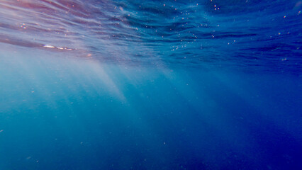 Sun rays underwater. The sun's rays pass through the water at an angle to the surface.