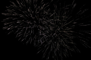 Fireworks in the night sky. Fireworks against a black sky. Sparks from a fireworks explosion on a black sky.