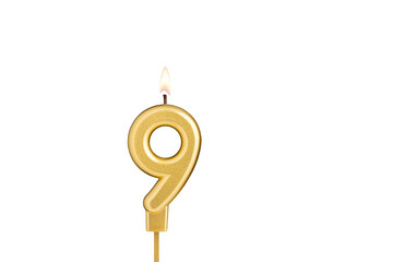 Golden number 9 birthday candle on white background