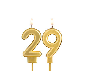 Golden number 29 birthday candle on white background