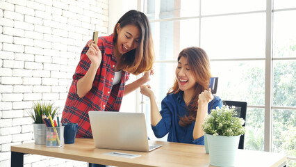 Two friends shopping using credit card online shopping on website laptop e-commerce website with smiling face, happiness. Happy asian women using laptop shopping online buy, payment newnormal concept - Powered by Adobe