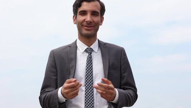 Modern businessman smiles and stretches his hand to the camera wishing to greet