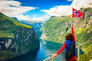 Tourist over Geirangerfjord with norwegian flag - obrazy, fototapety, plakaty