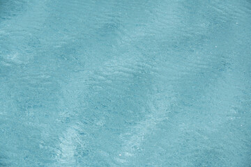 Background of blue water in swimming pool with sun reflection, ripple water wave in pool. Clear water background.