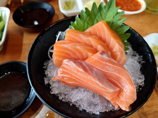 Salmon sashimi on black bowl