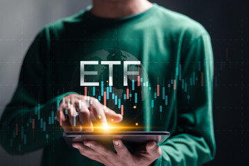 Fototapeta na wymiar ETF, Exchange traded fund. Financial technology business investment concept. Person using tablet with stock market growth graph on virtual screen.