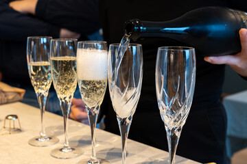 Birthday party, pouring of brut champagne bubbles cava or prosecco wine in tulip glasses with...