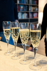 Birthday party, pouring of brut champagne bubbles cava or prosecco wine in tulip glasses with kitchen on background