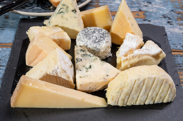 Tasting plate with small pieces of different French cheeses, variety of cheeses