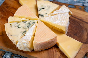 Tasting plate with small pieces of different French cheeses, variety of cheeses