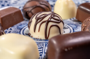 Variety of luxury belgian chocolate pralines bonbons on blue china porcelain plate, tea time