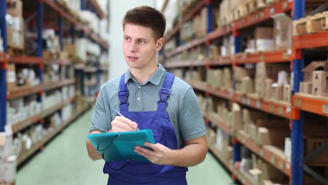 In warehouse of store, guy checks quantity of goods and receipt documents for products. High quality 4k footage