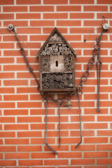 Wooden insects hotel for bugs en bees on brick wall