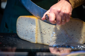 Cutting and tasting of different cheeses in Dutch cheese farm shop