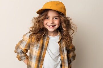 Portrait of a cute little girl with curly hair wearing a yellow cap