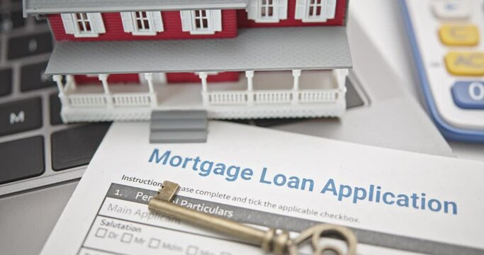Mortgage loan or home equity loan, financial concept : Model residential house, a key on mortgage application, depicting home loan or borrowing money to purchase a new home for first time homebuyer.	