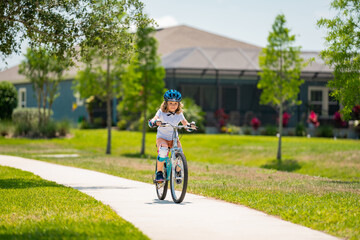 Child in safety helmet riding bike. Boy riding bike wearing a helmet outside. Child in safety helmet riding bike. Little kid boy learns to ride a bike. Kid on bicycle. Happy child in helmet riding a