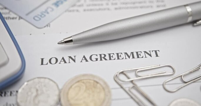 Business loan agreement or legal document concept : A pen on a loan agreement paper form. Loan agreement is a contract between a borrower and a lender, a compilation of various mutual promises.