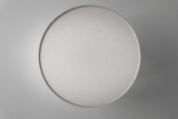 Round gray embossed shape on a surface. Textured background