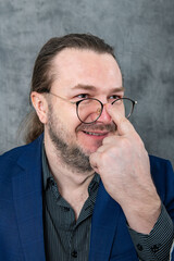 Fototapeta premium Professional businessman in blue suit working on laptop next to a green plant in modern office