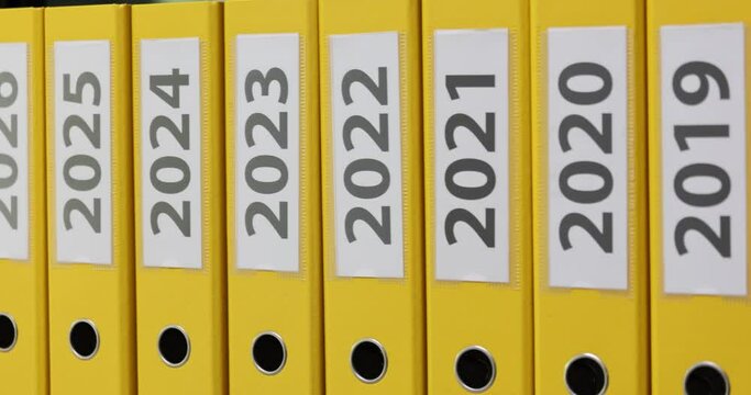 Yellow office folders with text labels of year profit and loss reports