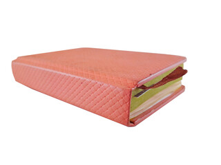 A pink leather-bound journal or book or folder used for notes with a bordered ribbon in the middle, isolated on white background with close up shot.