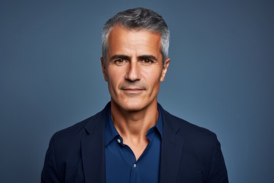 Portrait of a handsome mature man with grey hair over blue background.