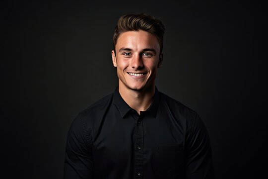 Portrait of a handsome young man in black shirt on dark background