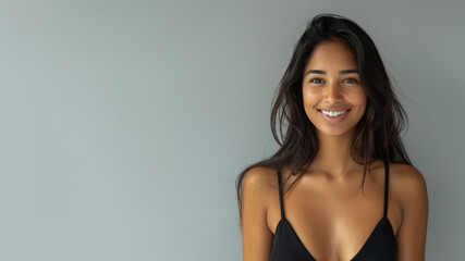 Indian woman wearing black ribbed V-Neck Body smiling isolated on grey