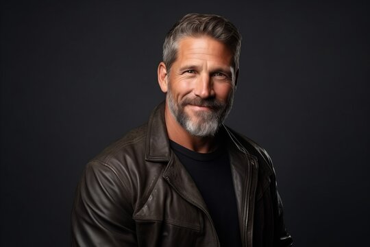 Portrait of a handsome mature man with beard and mustache in leather jacket.