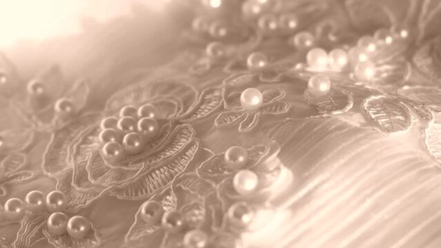 Close up of white wedding dress lace and fabric with beads and pearls