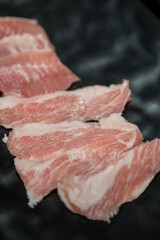 Premium sliced marble beef or pork meat which is preparing for BBQ grilling meal. Food ingredient object, close-up and selective focus.