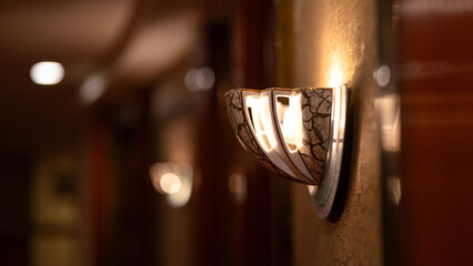 A classic luxury designed wall lamp with corridor as blurred background. Interior decoration object...