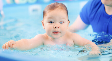 Fototapeta na wymiar Banner Sport Healthcare in pool for babies. Portrait Cute happy laughing baby girl swimming.