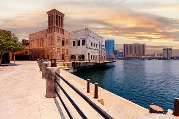Zelfklevend Fotobehang Pier marina of old city for tourist wooden ship cruise Dhow in Dubai, United Arab Emirates. © Parilov