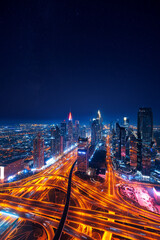 Amazing skyline of city center Dubai. Aerial top view night cityscape with skyscrapers with illuminated and highway. Business and financial modern district of UAE.
